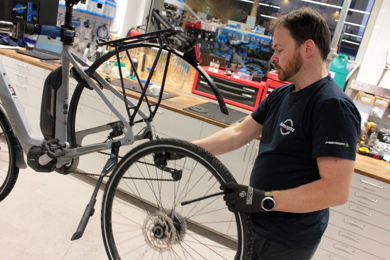 SImen Thorvaldsen fjerne et hjul på en elsykkel på Bike Fixx Lysaker